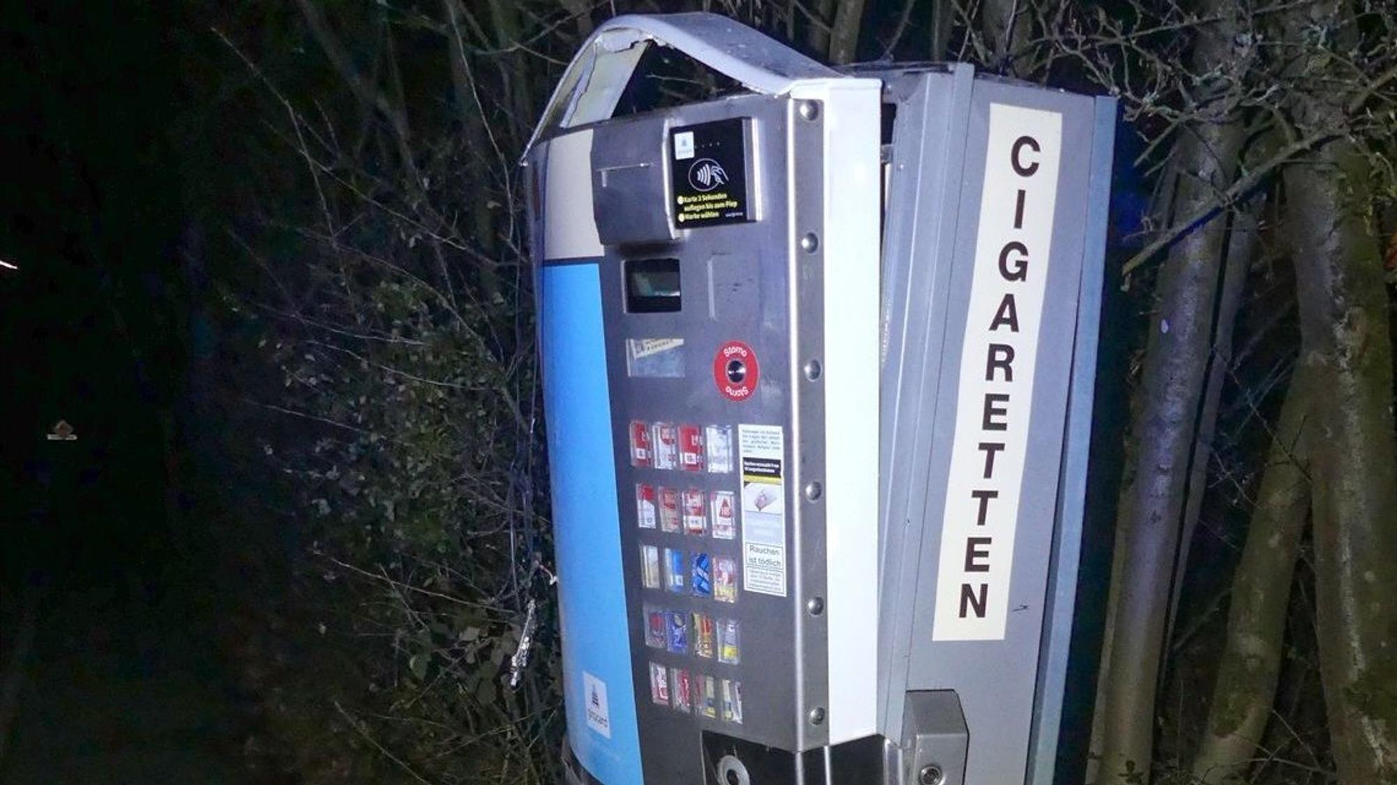 Ein aufgesprengter Zigarettenautomat wird mit Blitzlicht im Dunkeln angeleuchtet.