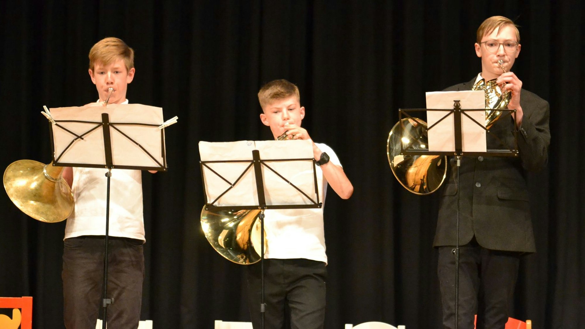 Drei Nachwuchsmusiker blasen auf der Bühne des Euskirchener Stadttheaters in ihre Instrumente.