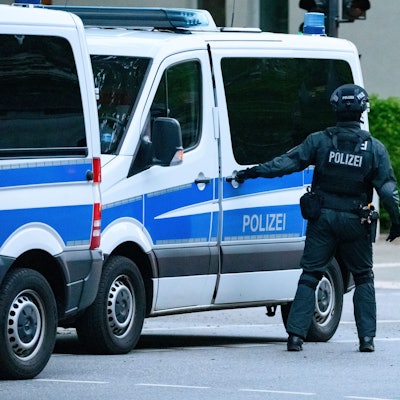 Ein Polizist der USE-Einheit steht an seinem Einsatzfahrzeug.