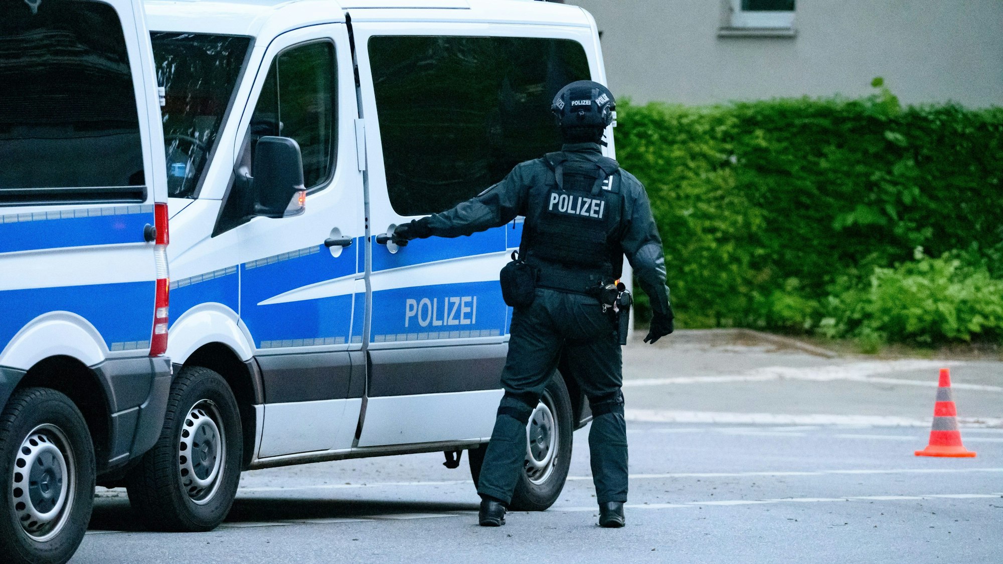 Ein Polizist der USE-Einheit steht an seinem Einsatzfahrzeug.