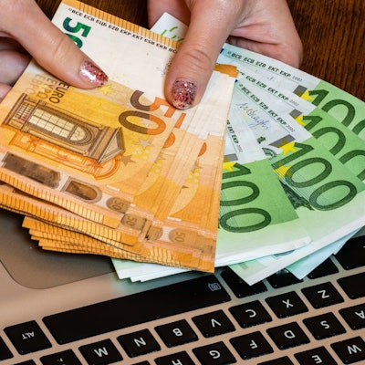 Hand hält Geldscheine.