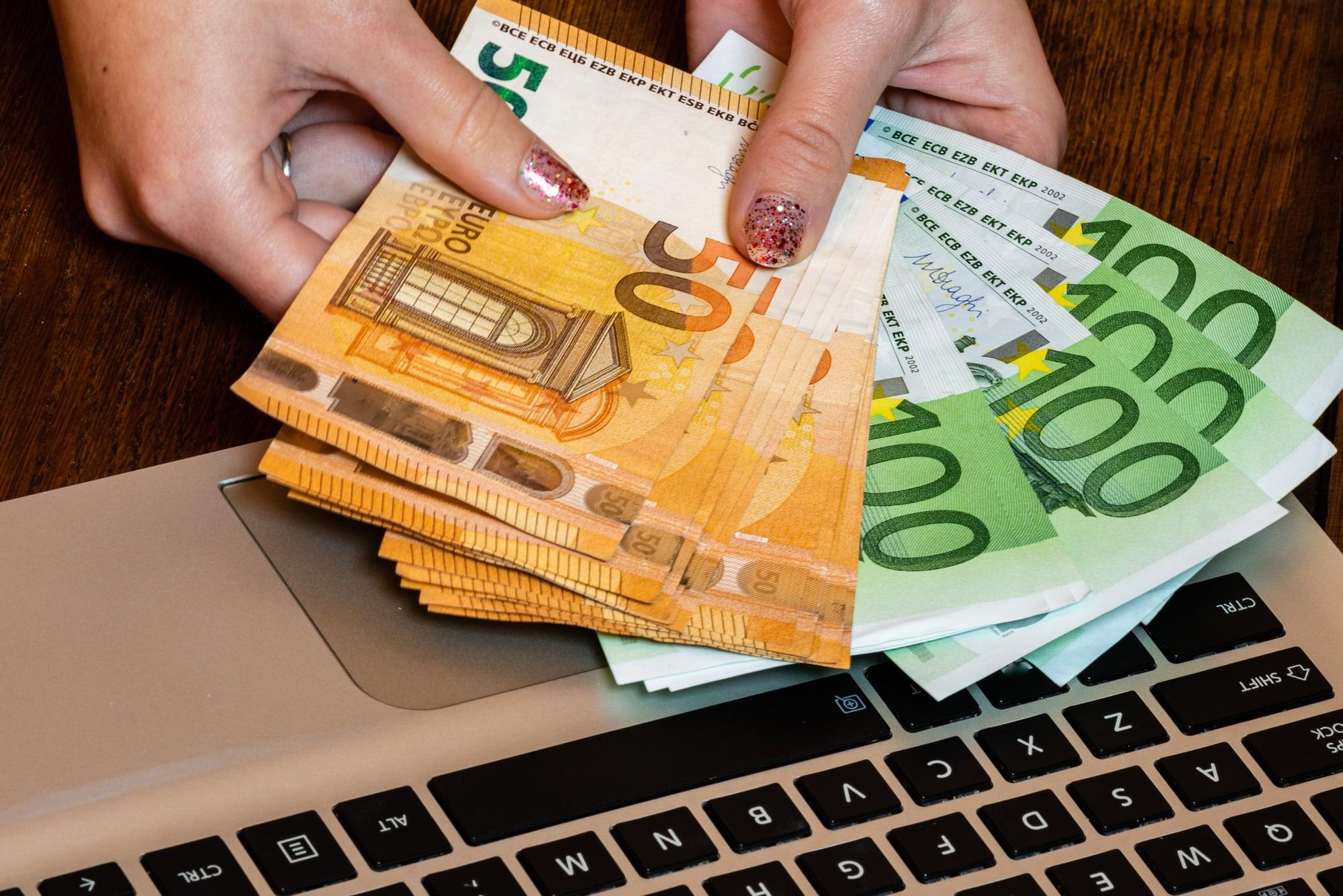 Hand hält Geldscheine.