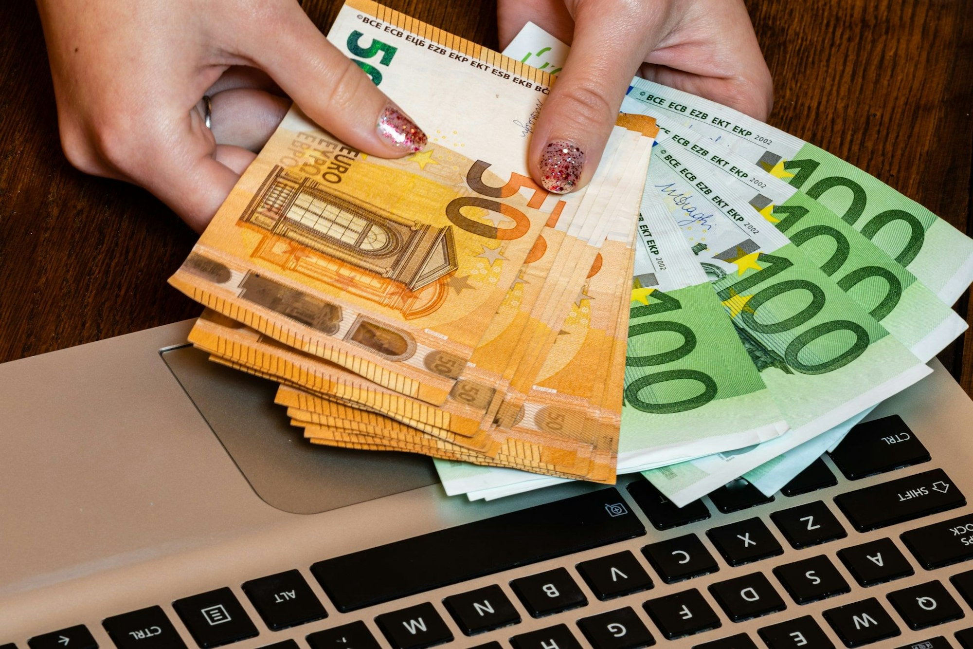 Hand hält Geldscheine.