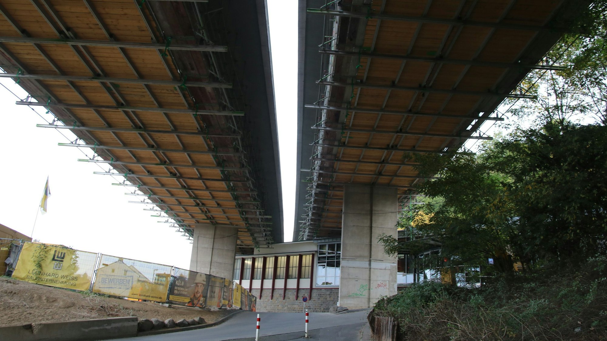 Mächtige Betonpfeiler tragen die Brücke, die über der Altstadt von Königswinter verläuft. Im Hintergrund ist die Talstation der Drachenfelsbahn zu sehen.