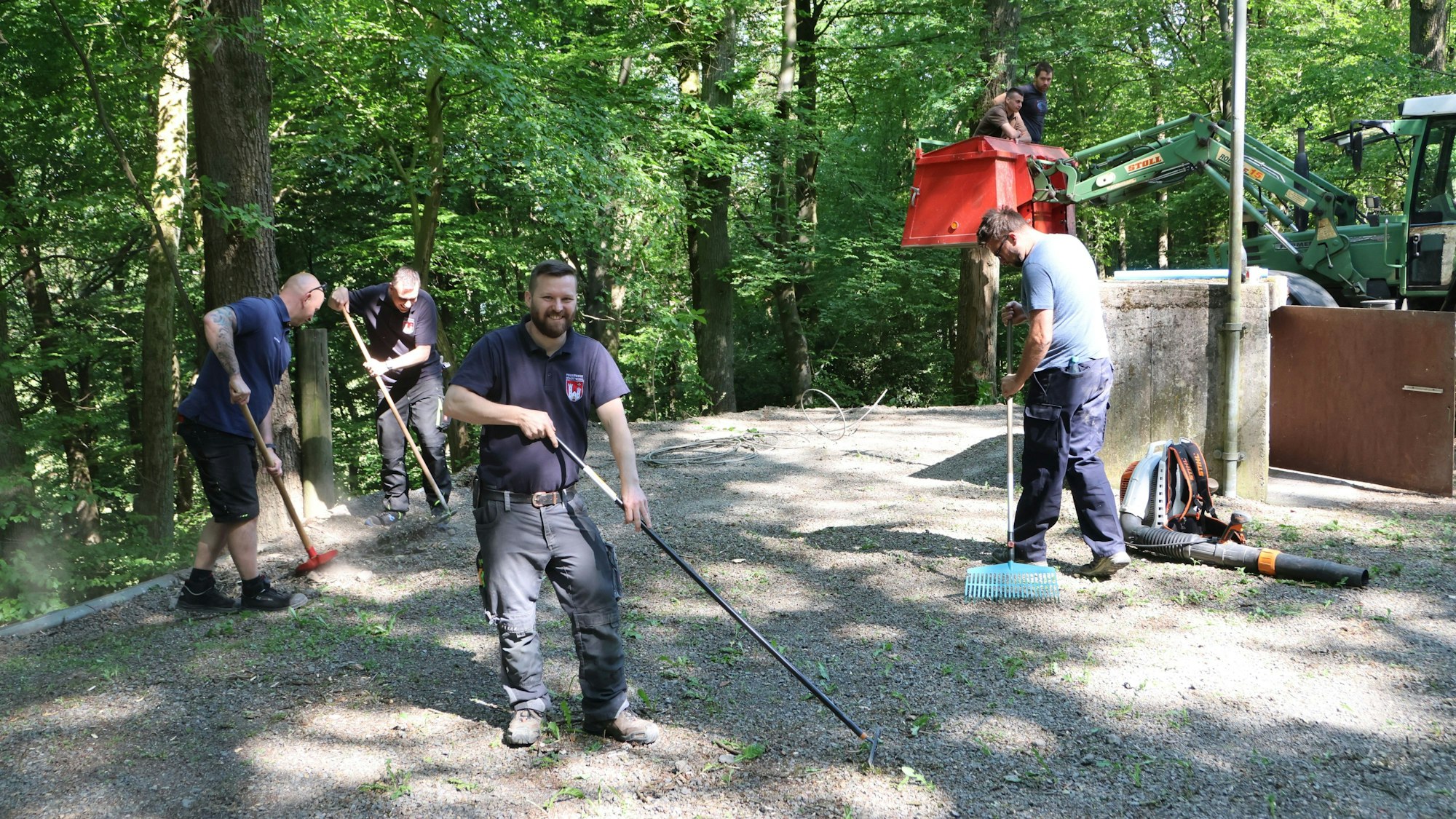 Mehrere Männer bringen einen Schotterplatz auf Vordermann.
