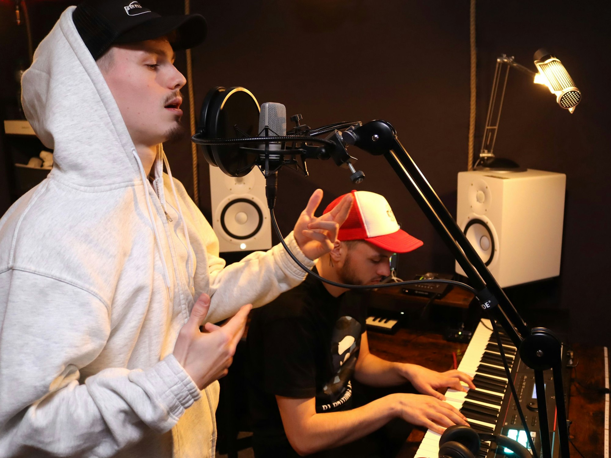 Der Rapper Liaze steht im Musikstudio am Mikrofon, im Hintergrund spielt Equal Keyboard.
