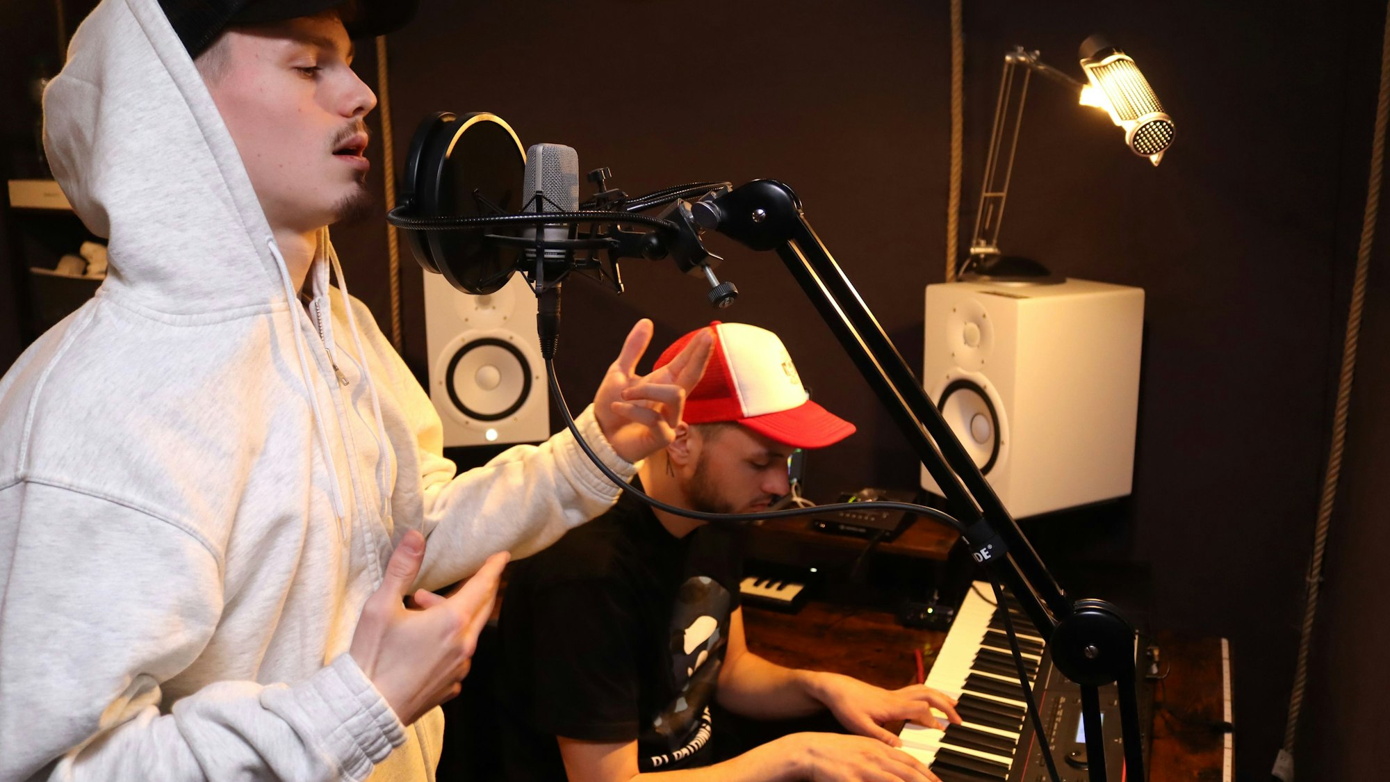 Liaze steht am Mikro im Studio in Blankenheim, im Hintergrund sitzt MTJ am Keyboard.