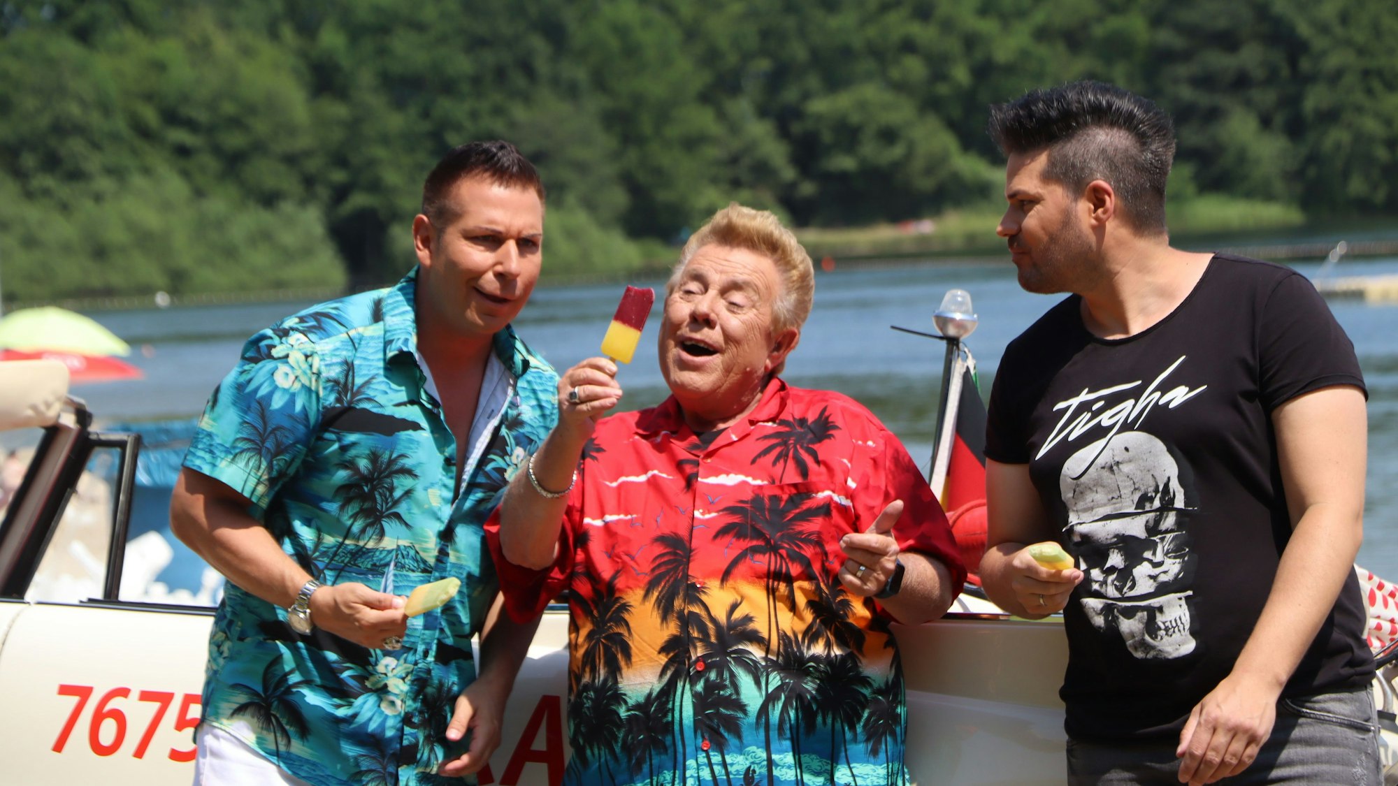 „Wir lieben Eis am Stiel und jede Menge Party“, singen Schauspieler Zachi Noy (Mitte), Sänger und Co-Produzent Andy Andress (l.), sowie Produzent und Sänger Denny Fabian (r.) vor laufender Kamera.