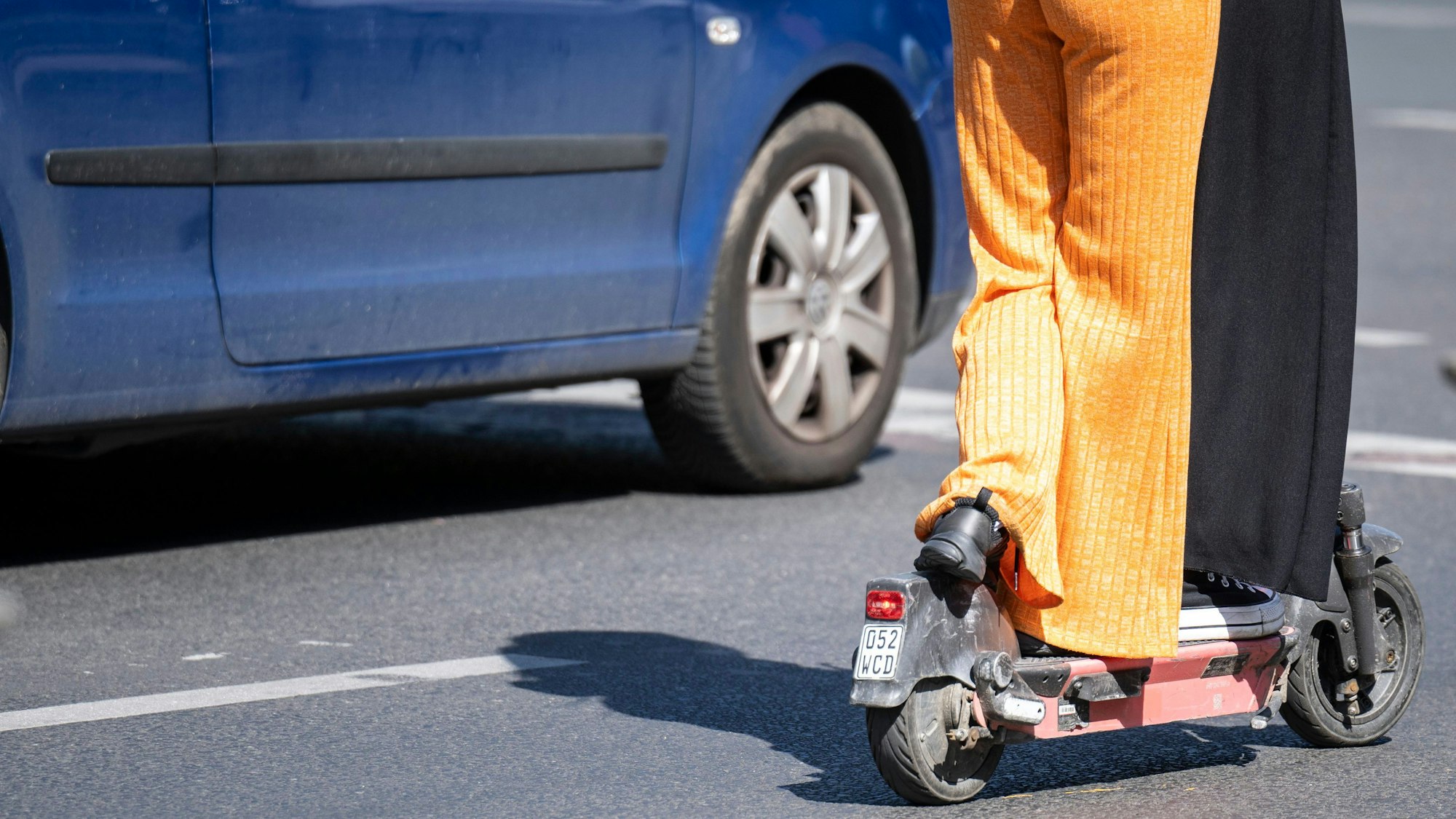 Zwei Frauen stehen auf einem E-Scooter.
