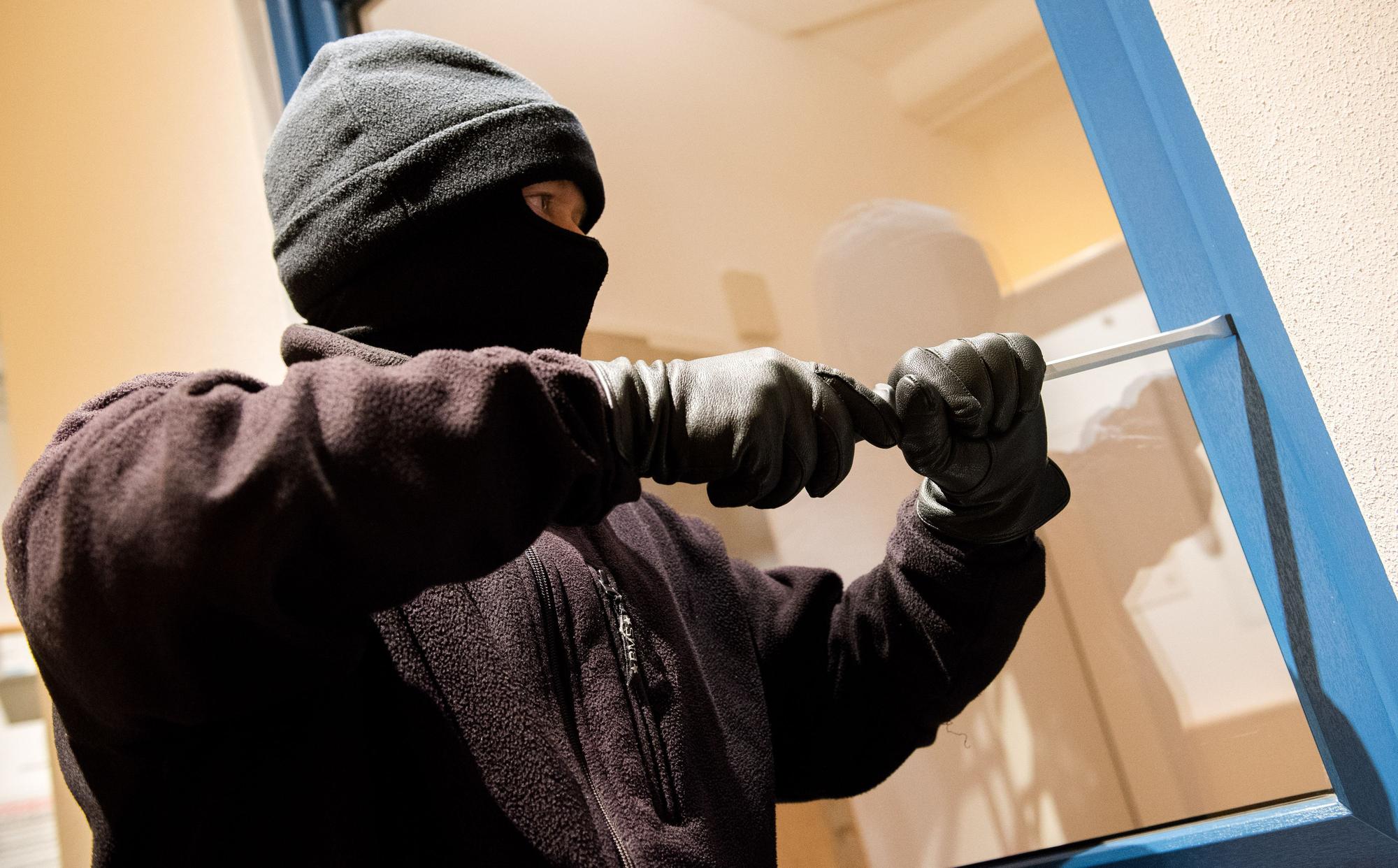 Ein als Einbrecher verkleideter Mann hebelt in der Kriminalpolizeilichen Beratungsstelle der Polizei ein Fenster auf. Dank guter Prävention sind nach Angaben der Polizei 51,3 Prozent der Einbruchsversuche in der Hansestadt in 2021 gescheitert. (zu dpa «Mehrzahl der Einbruchsversuche in Hamburg scheitert - Gute Prävention») +++ dpa-Bildfunk +++