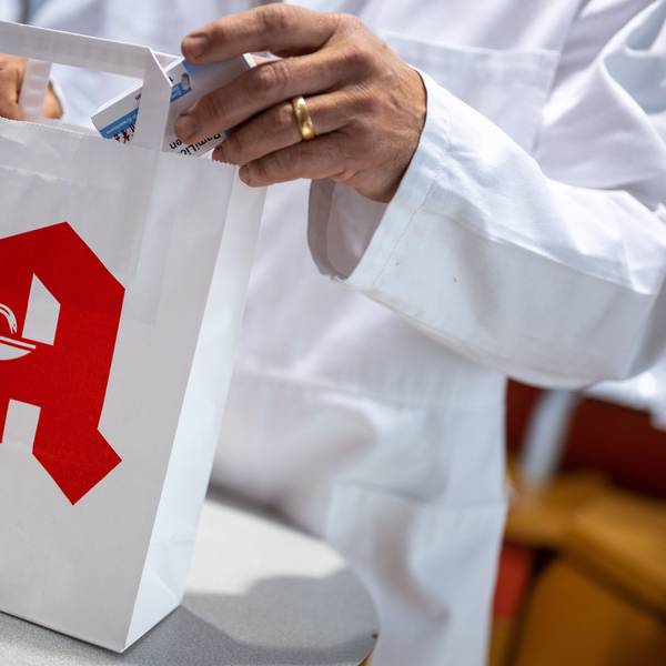 ILLUSTRATION - 05.06.2023, Berlin: Ein Apotheker legt in einer Apotheke eine Packung mit Tabletten in eine Papiertasche mit Apotheken-Logo. Foto: Monika Skolimowska/dpa +++ dpa-Bildfunk +++