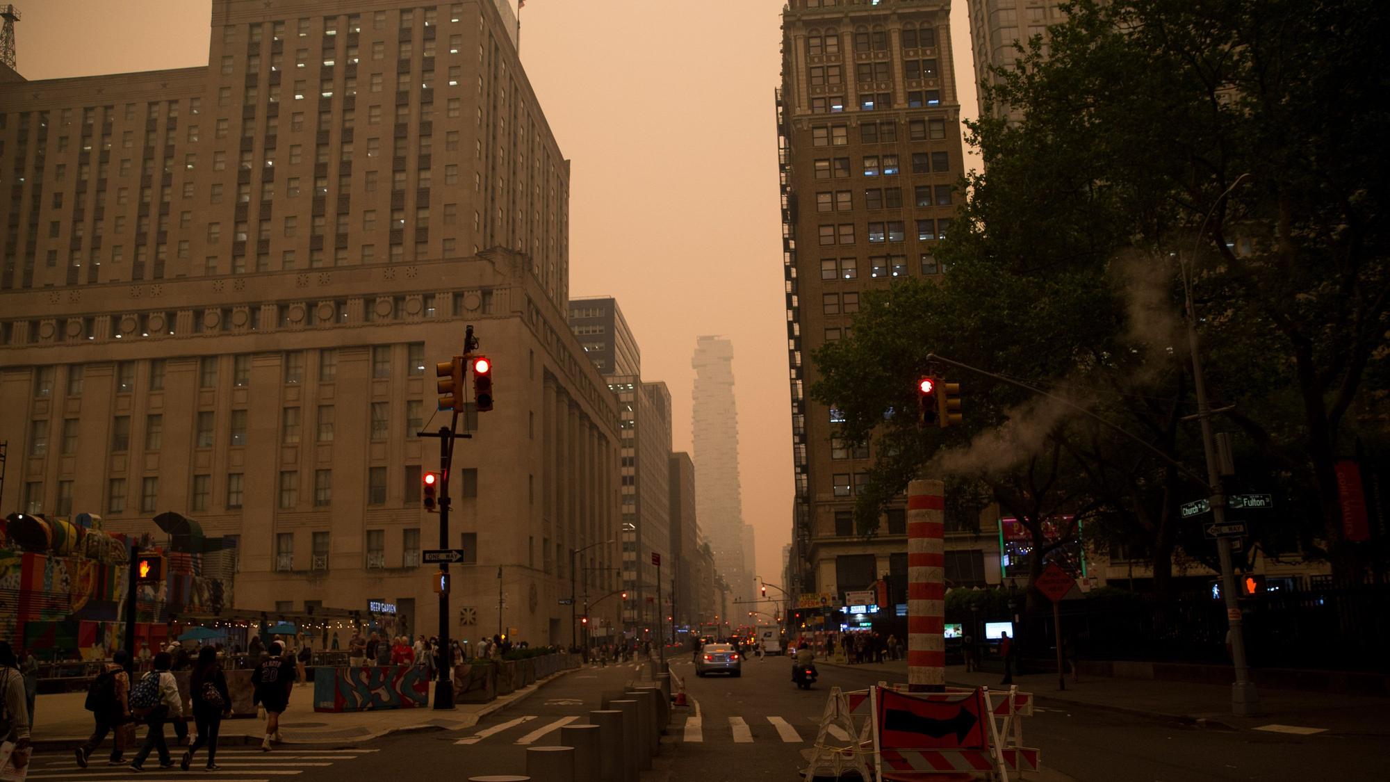 07.06.2023, USA, New York: Dunst hängt im Himmel über Manhattan. Der Rauch zahlreicher schwerer Waldbrände in Kanada hat Teile der US-Ostküste eingehüllt und in der Millionenmetropole New York für die schlechteste Luftqualität seit Jahrzehnten gesorgt. Die Schwaden Hunderter Feuer im Osten Kanadas zogen in südliche Richtung und führten unter anderem in New York zu einem dichten, nebligen Schleier und einer zeitweise orangenen Färbung des Himmels. Foto: Vanessa Carvalho/ZUMA Press Wire/dpa +++ dpa-Bildfunk +++
