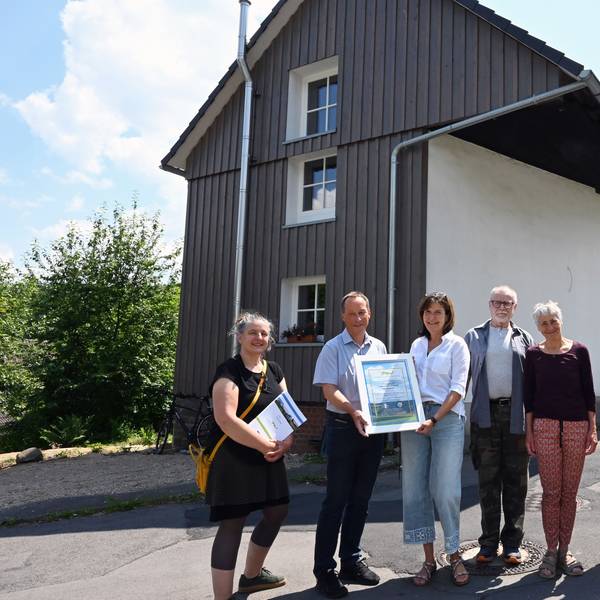 Kreisdezernent Frank Herhaus überreicht die Leader-Urkunde an Mitglieder der Oberholzener Interessengemeinschaft.