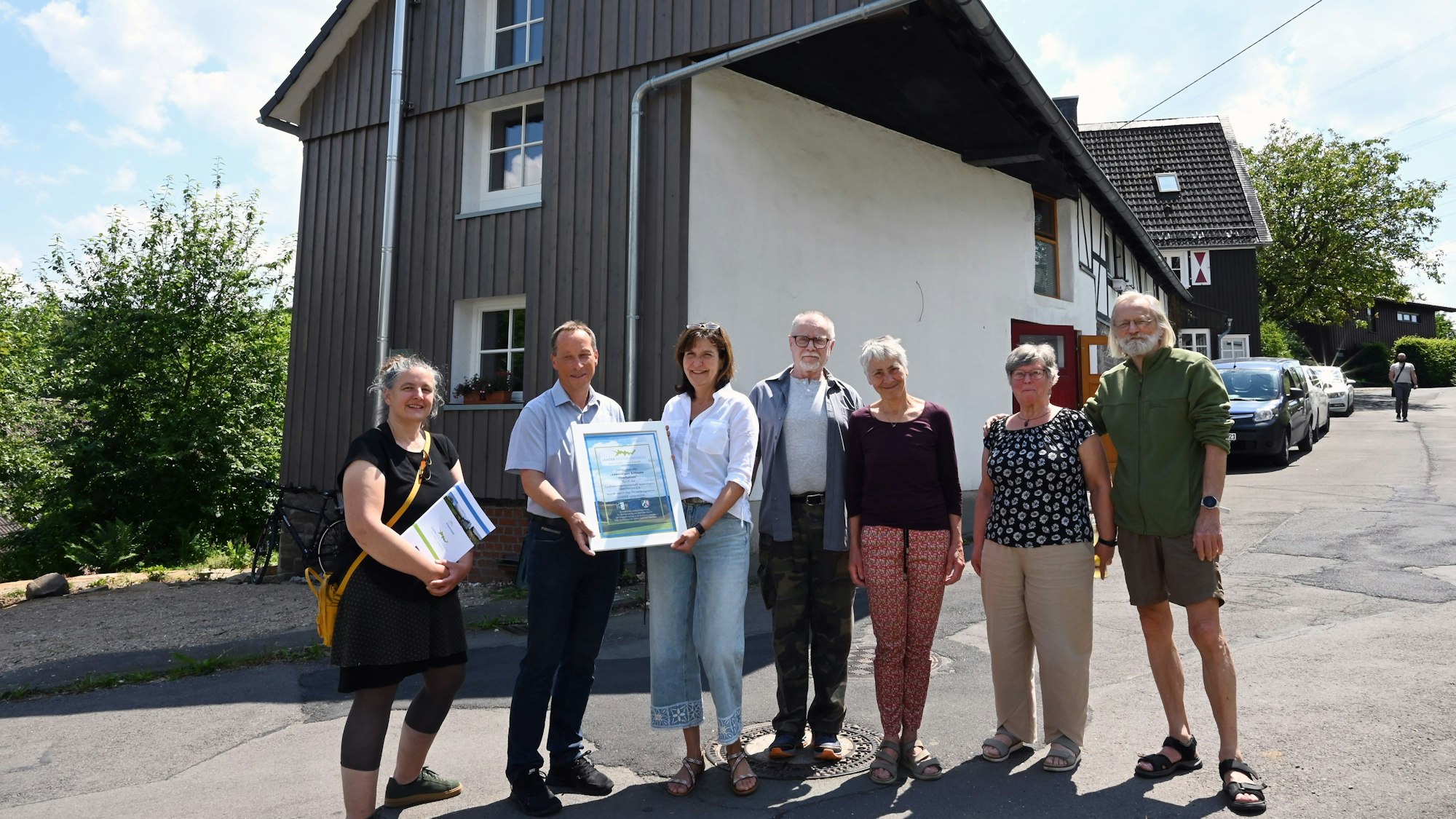 Kreisdezernent Frank Herhaus überreicht die Leader-Urkunde an Mitglieder der Oberholzener Interessengemeinschaft.
