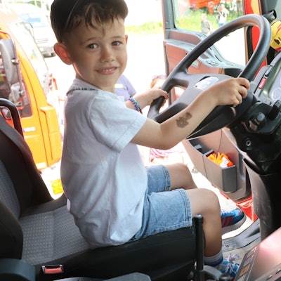 Ein Kind aus Eckenhagen sitzt am Steuer eines Feuerwehrautos.