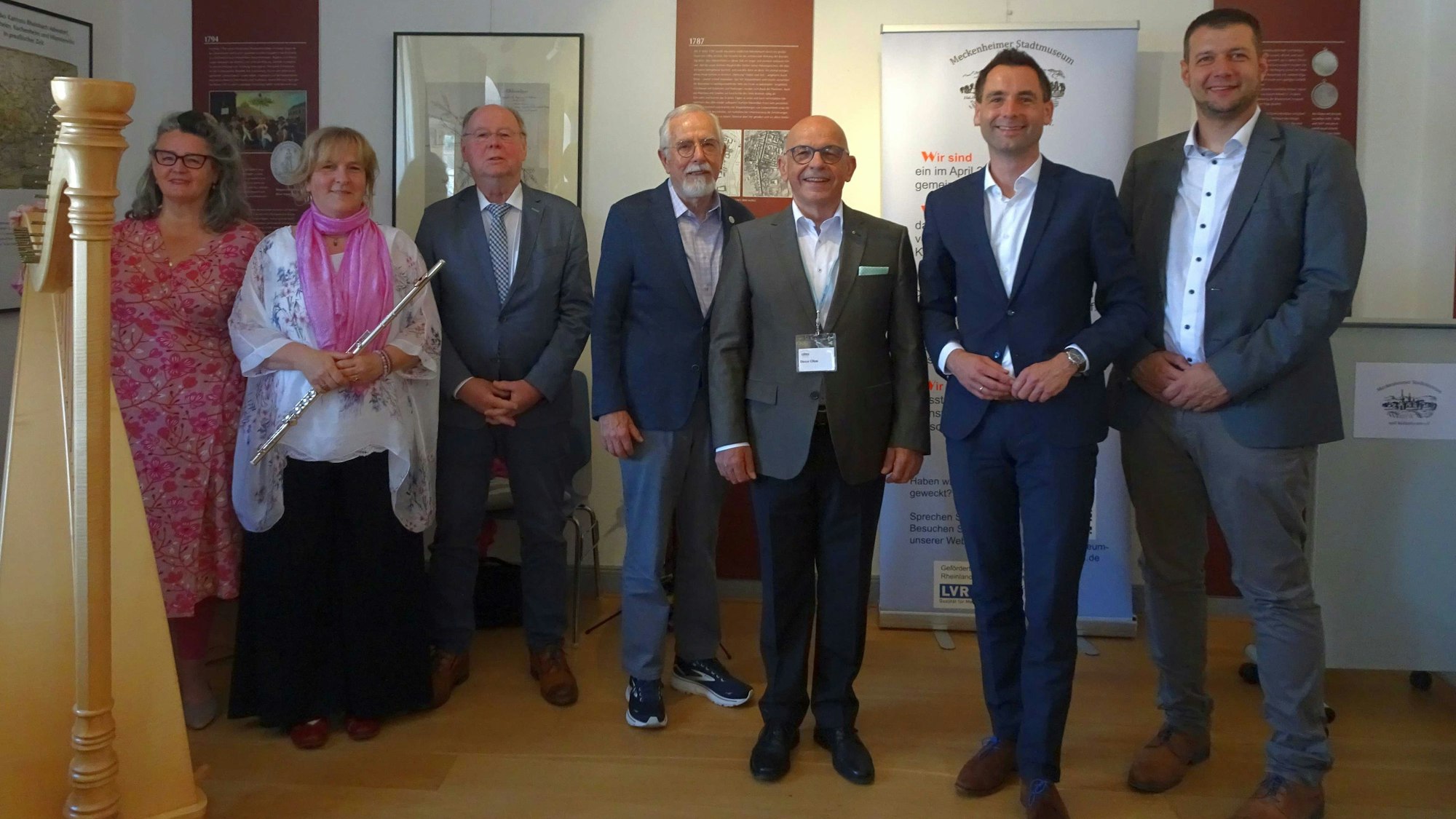 Musikalischer Festakt mit von links: Katrin Mahnig, Harfe und Monika Pfennigs, Querflöte. Daneben der Lehrerssohn Bernhard Wiktorin, Vereinsmitglied Walter Kümmel, Vorsitzender Dieter Ohm, der CDU-Landtagsabgeordnete Jonathan Grunwald und Meckenheims Vize-Bürgermeister Tobias Pötzsch.