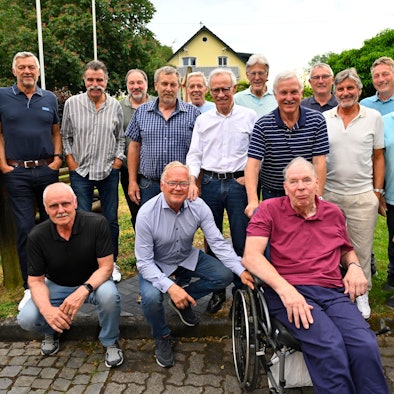 Eine Gruppe von Männern steht beisammen. Einer von ihnen sitzt im Rollstuhl.