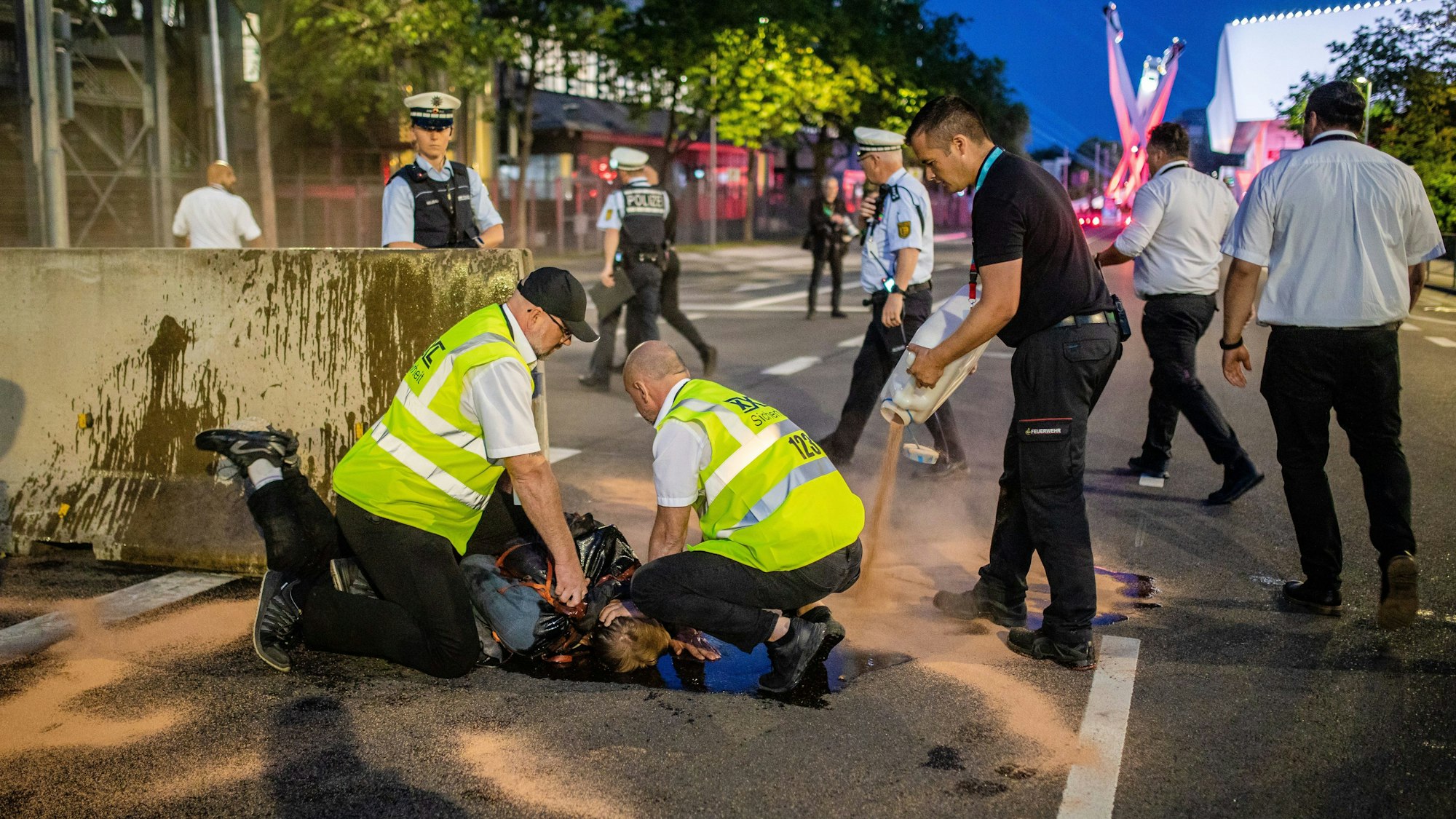 Stuttgart: Sicherheitsleute halten Abseits der Festveranstaltung zu 75 Jahren Porsche-Sportwagen einen Klimaaktivisten auf.