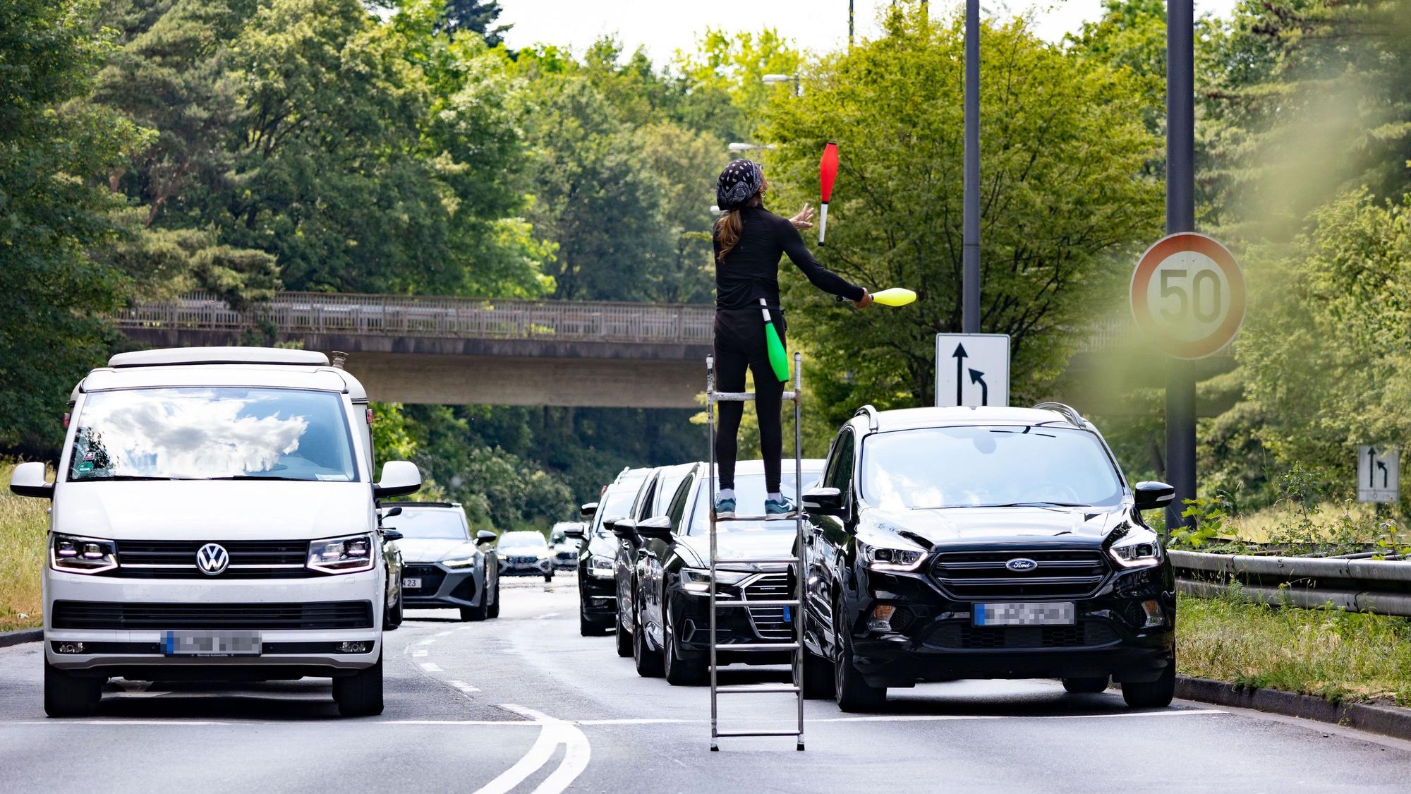 Bei halsbrecherischen Kunststücken lässt Jongleur Pohemnerss Sanchez seine bunten Keulen hoch über den Autodächern fliegen.