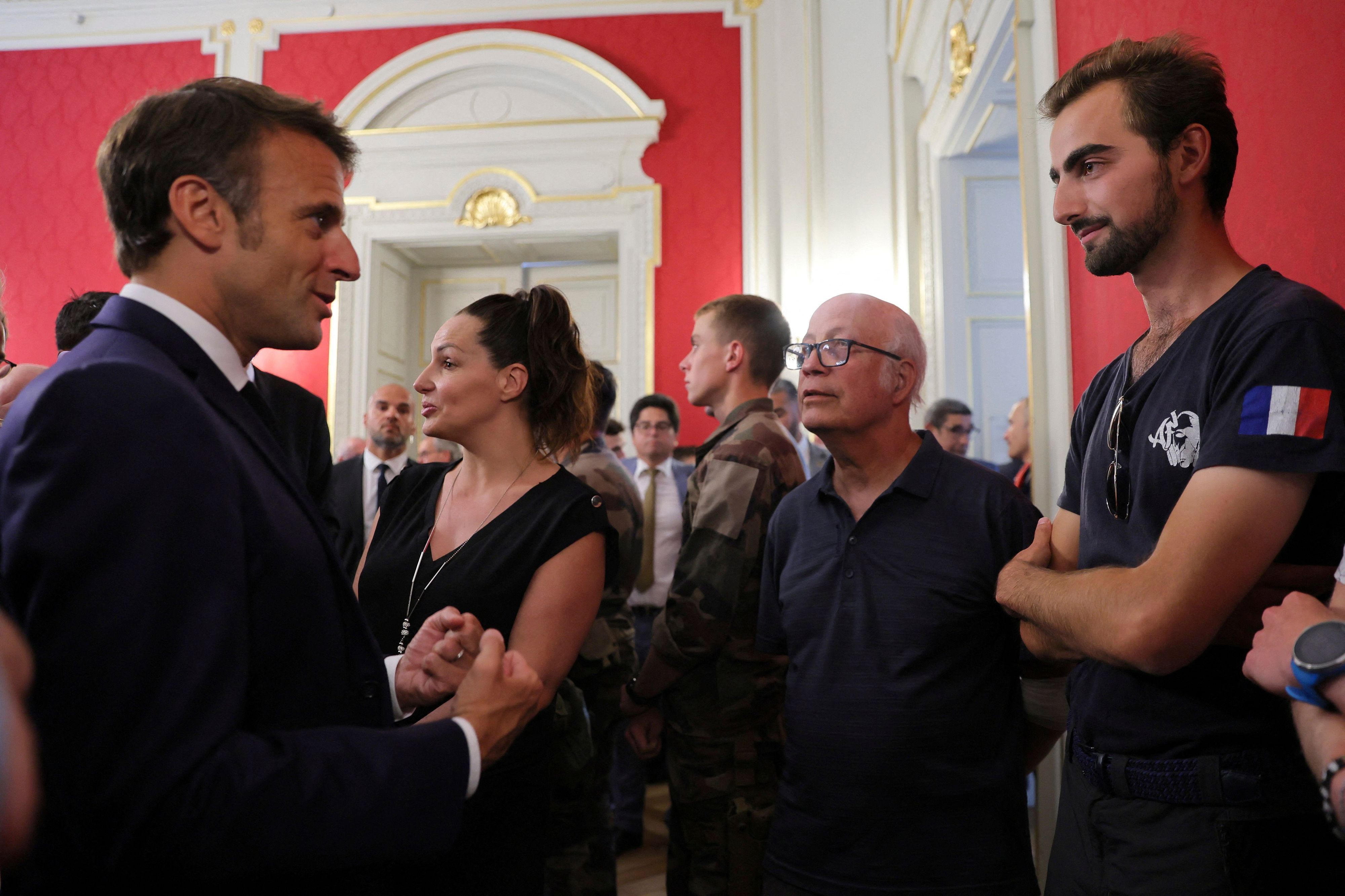 Die beiden Männer stehen sich gegenüber. Macron im Anzug und Henri im T-Shirt.