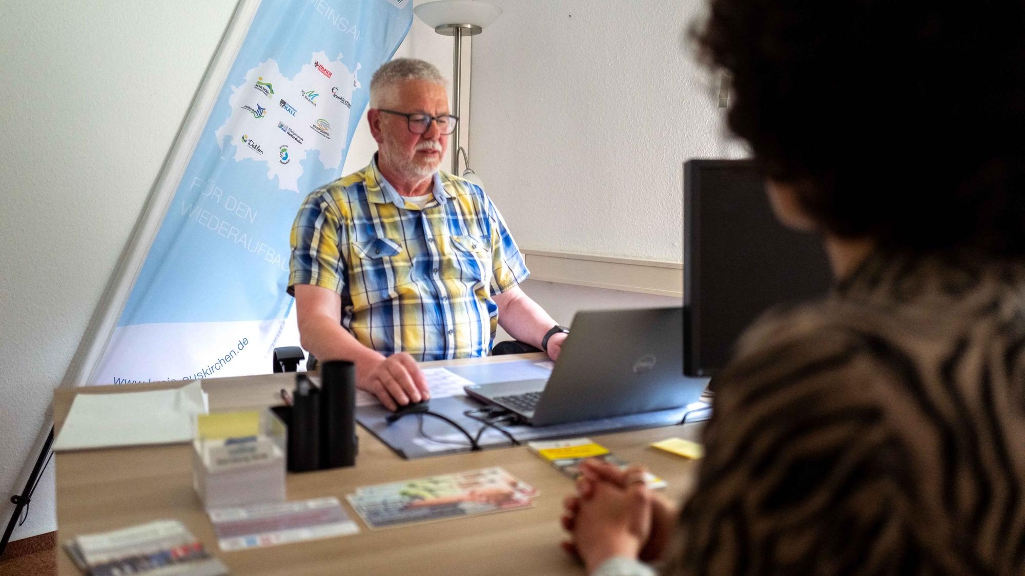 Karl-Georg Hardy sitzt am Computer und hilft beim Ausfüllen des Wiederaufbauantrags.