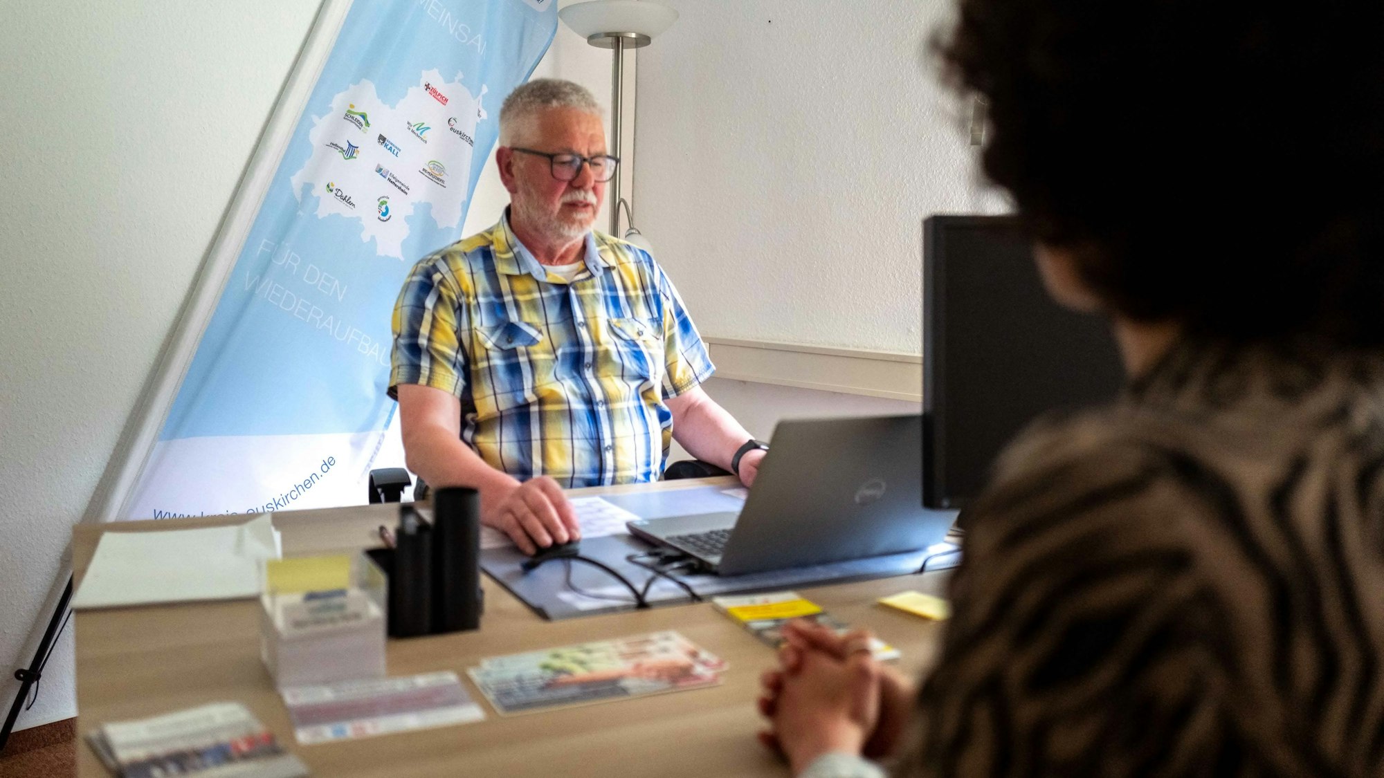 Karl-Georg Hardy sitzt am Computer und hilft beim Ausfüllen des Wiederaufbauantrags.