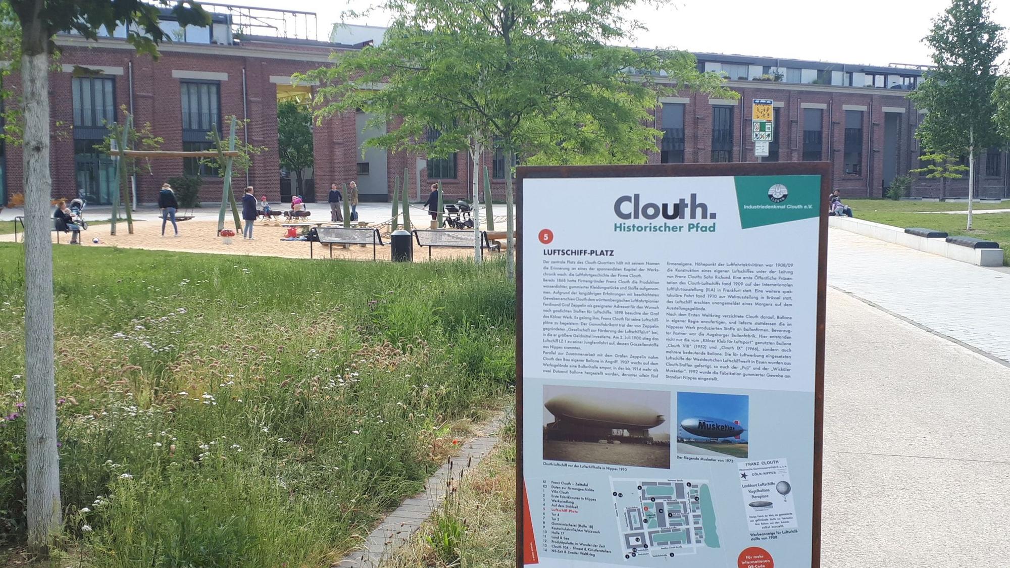 Zu sehen ist eine Infotafel zum historischen Clouth-Pfad auf dem ehemaligen Areal der Clouth-Werke in Nippes.