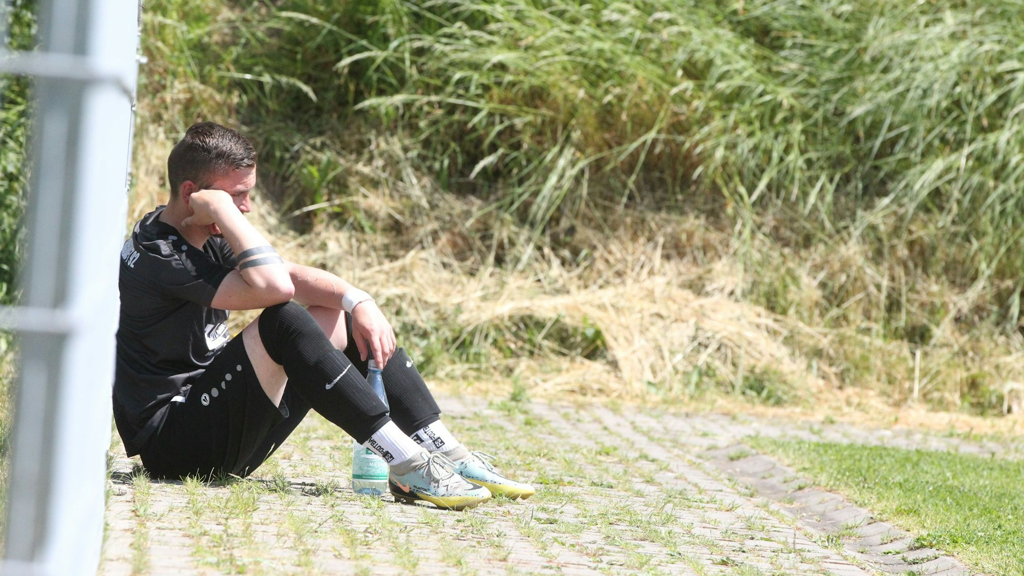 Gian-Luca Züll sitzt traurig am Pfosten, den Kopf auf die Hand gestützt.