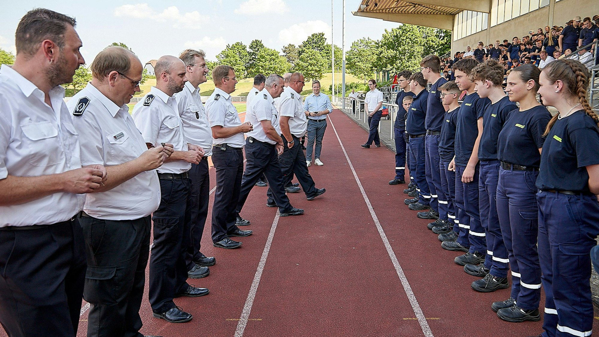 Eine Reihe Männer steht einer Reihe Jugendlicher gegenüber: Es sind Leiter der Feuerwehren aus dem Kreis Euskirchen, die Jugendfeuerwehrleuten die Leistungsspange übergeben.