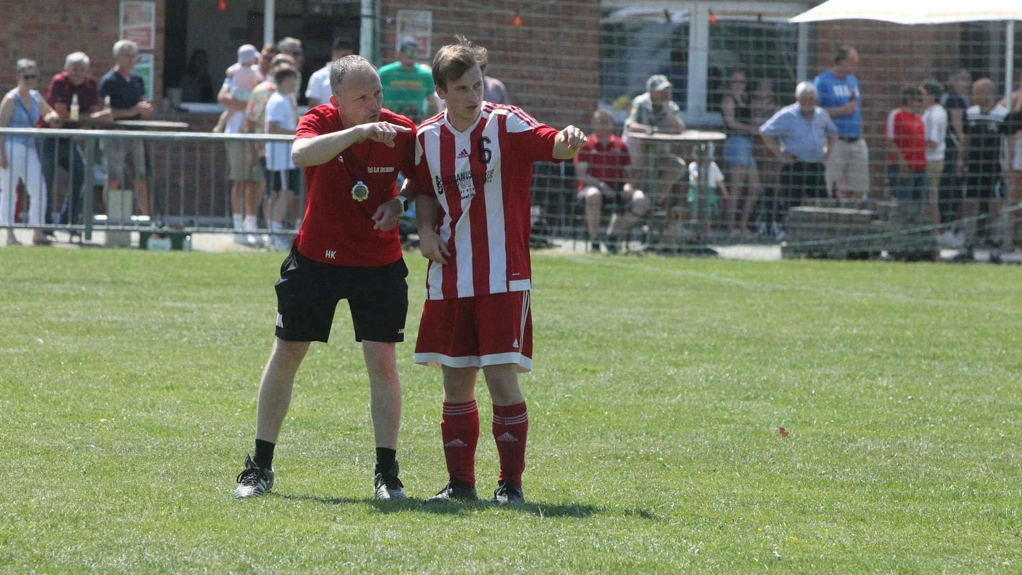 Heiko Kistemann instruiert Tim Gruhn auf dem Spielfeld.