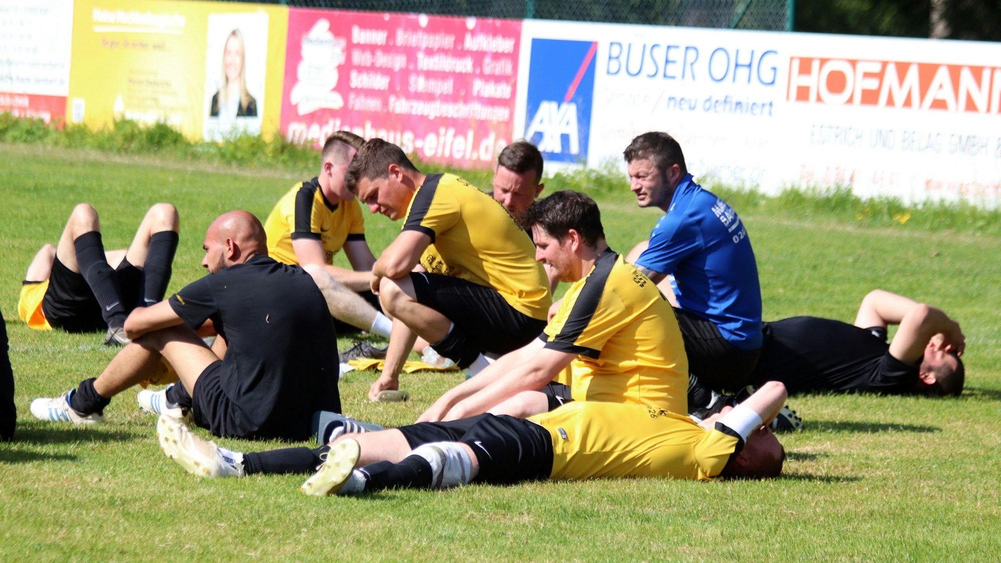 Spieler des SSV Golbach sitzen und liegen auf dem Rasen.