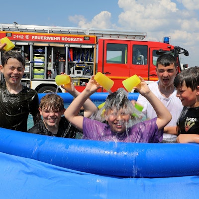 Kinder spielen in einem Pool.
