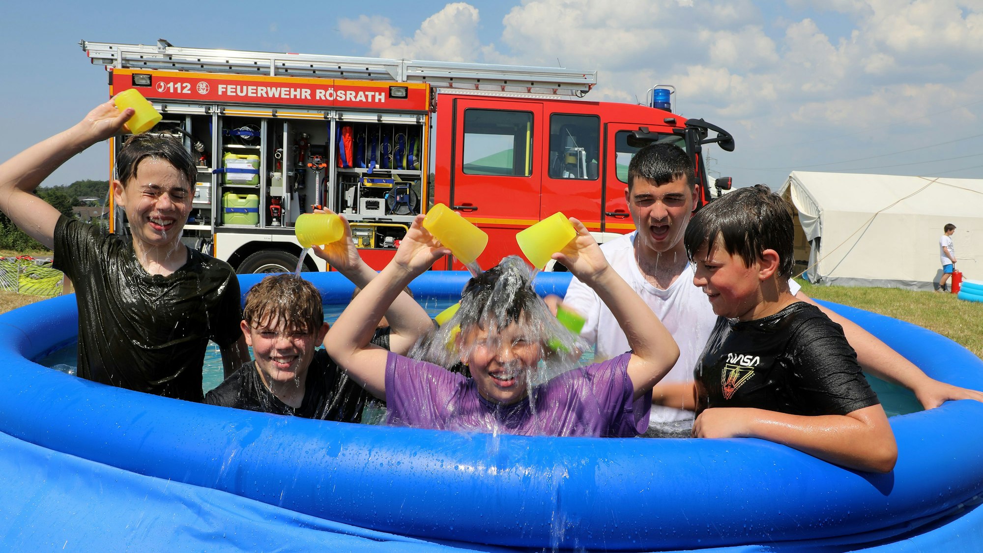 Kinder spielen in einem Pool.