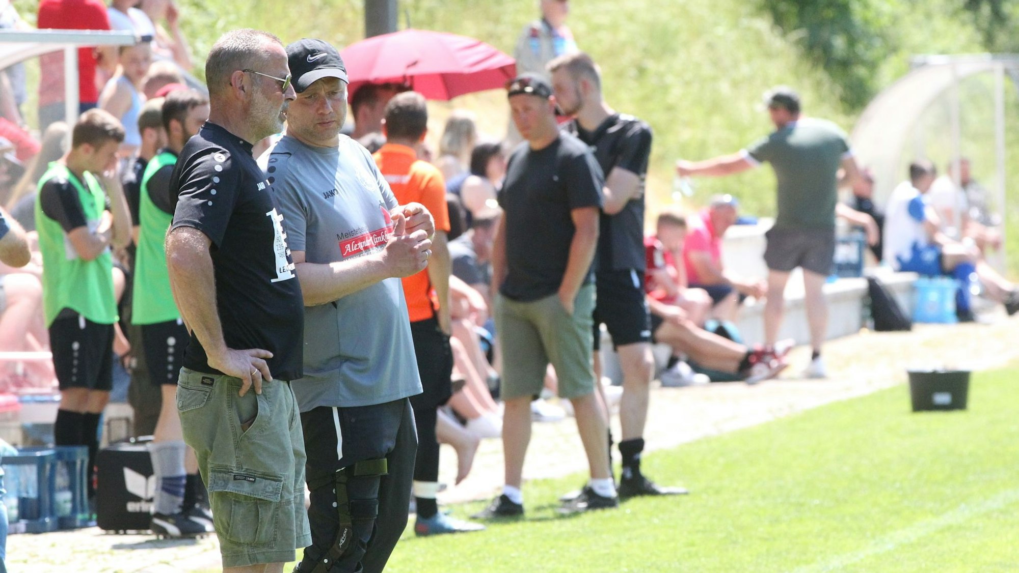 Die Trainer der SG 92 II beraten sich vor der Ersatzbank.