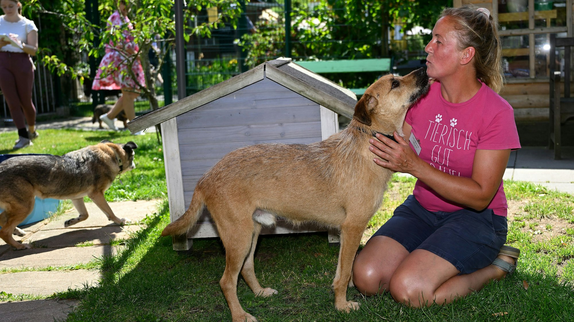 Mitarbeiterin des Schutzhofes mit einem Hund.
