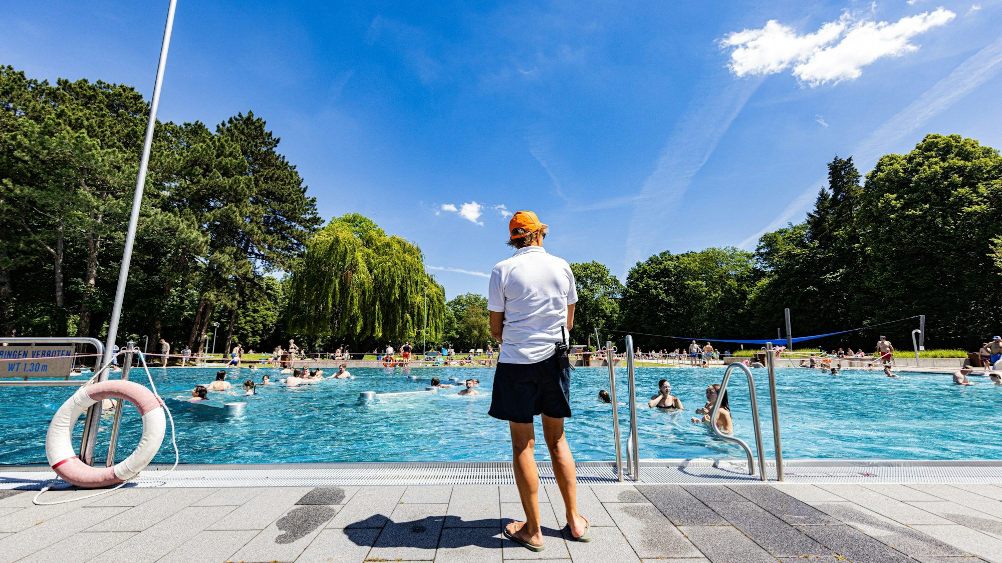 Bademeister steht am Rand vom Stadionbad.