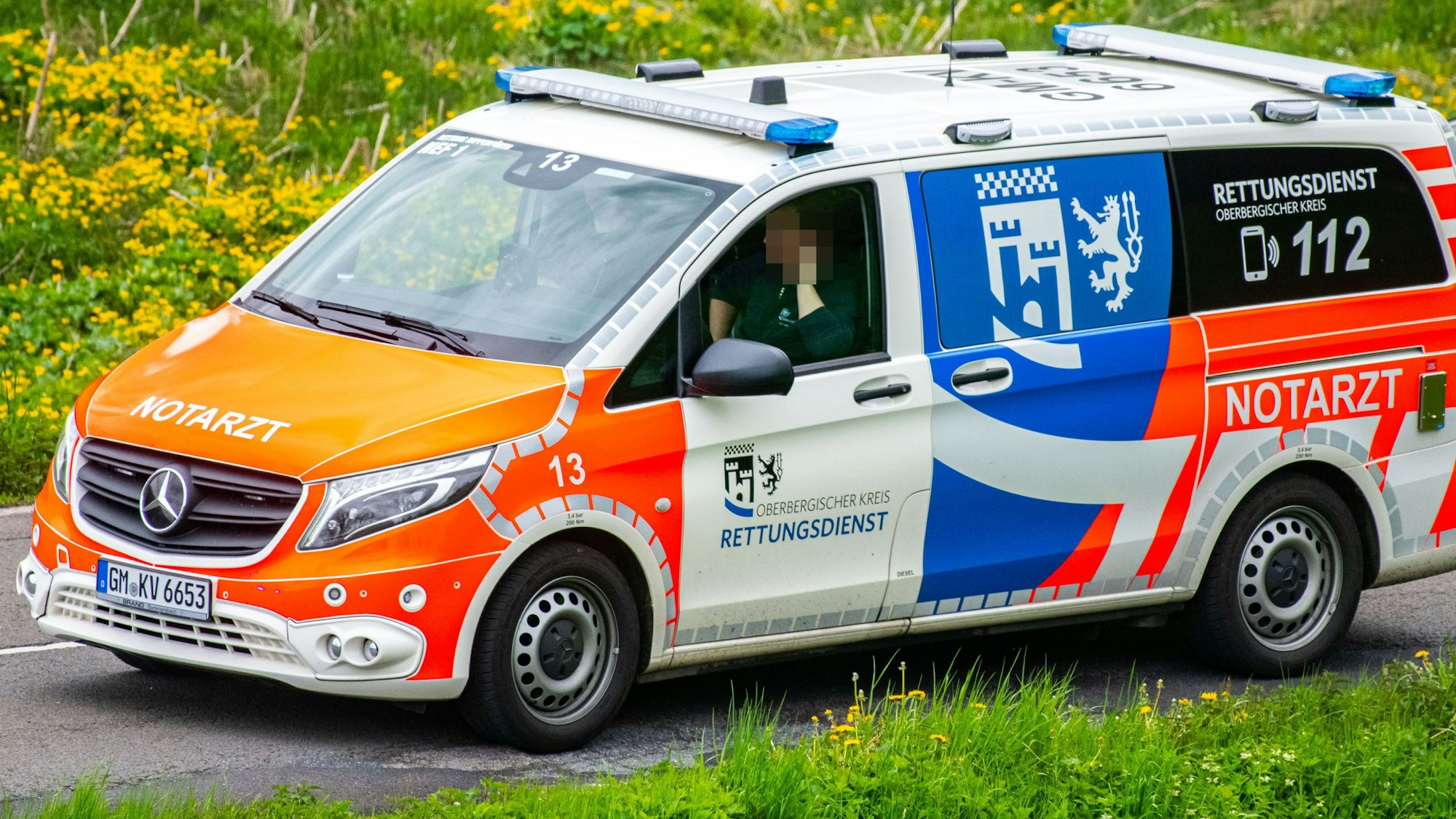 Ein Notarzt-Einsatzfahrzeug des Rettungsdienstes des Oberbergischen Kreises steht auf einer Landstraße.
