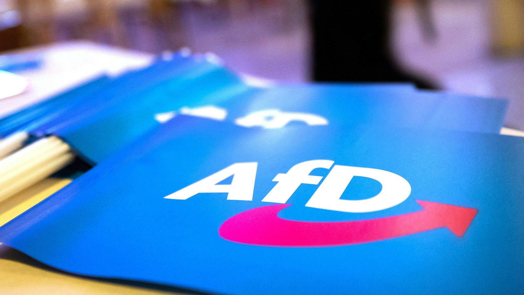 Fähnchen mit dem Logo der AfD liegen auf einem Tisch.