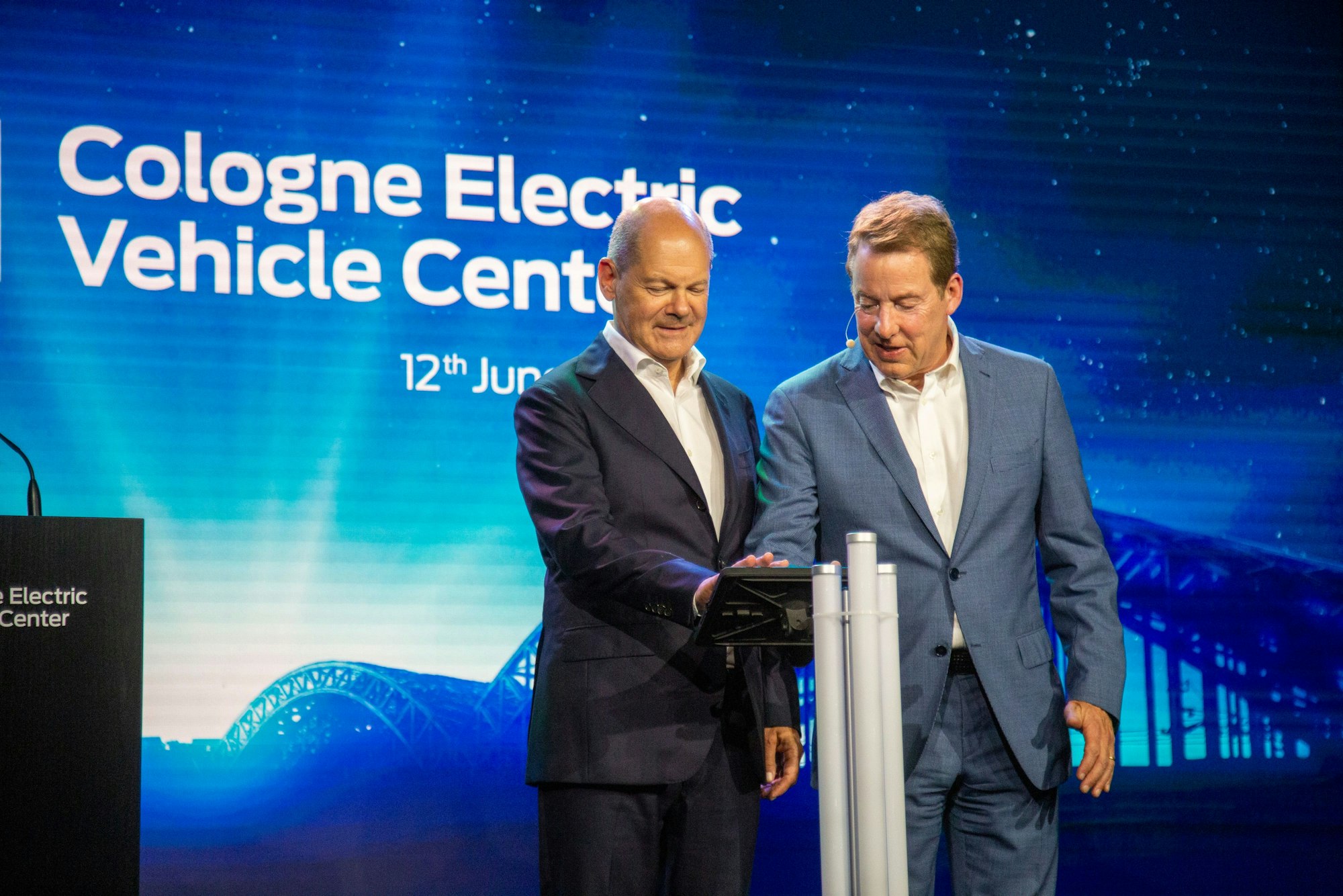 Bundeskanzler Olaf Scholz (l, SPD) und William Clay Ford, Vorstandsvorsitzender von Ford, drücken bei der Vorab-Eröffnungsfeier des Ford Cologne Electric Vehicle Center symbolisch den Startknopf.