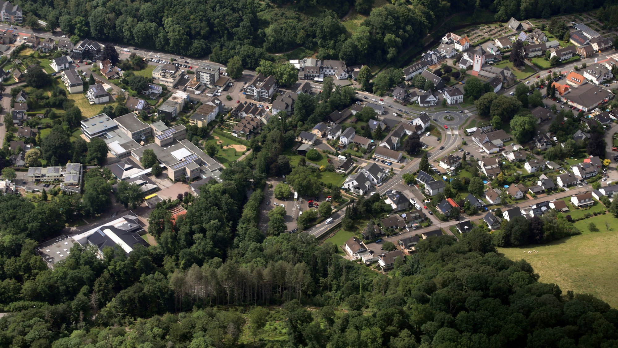 Eine Luftaufnahme von Odenthal: Häuser stehen nahe von Feldern und Bäumen.