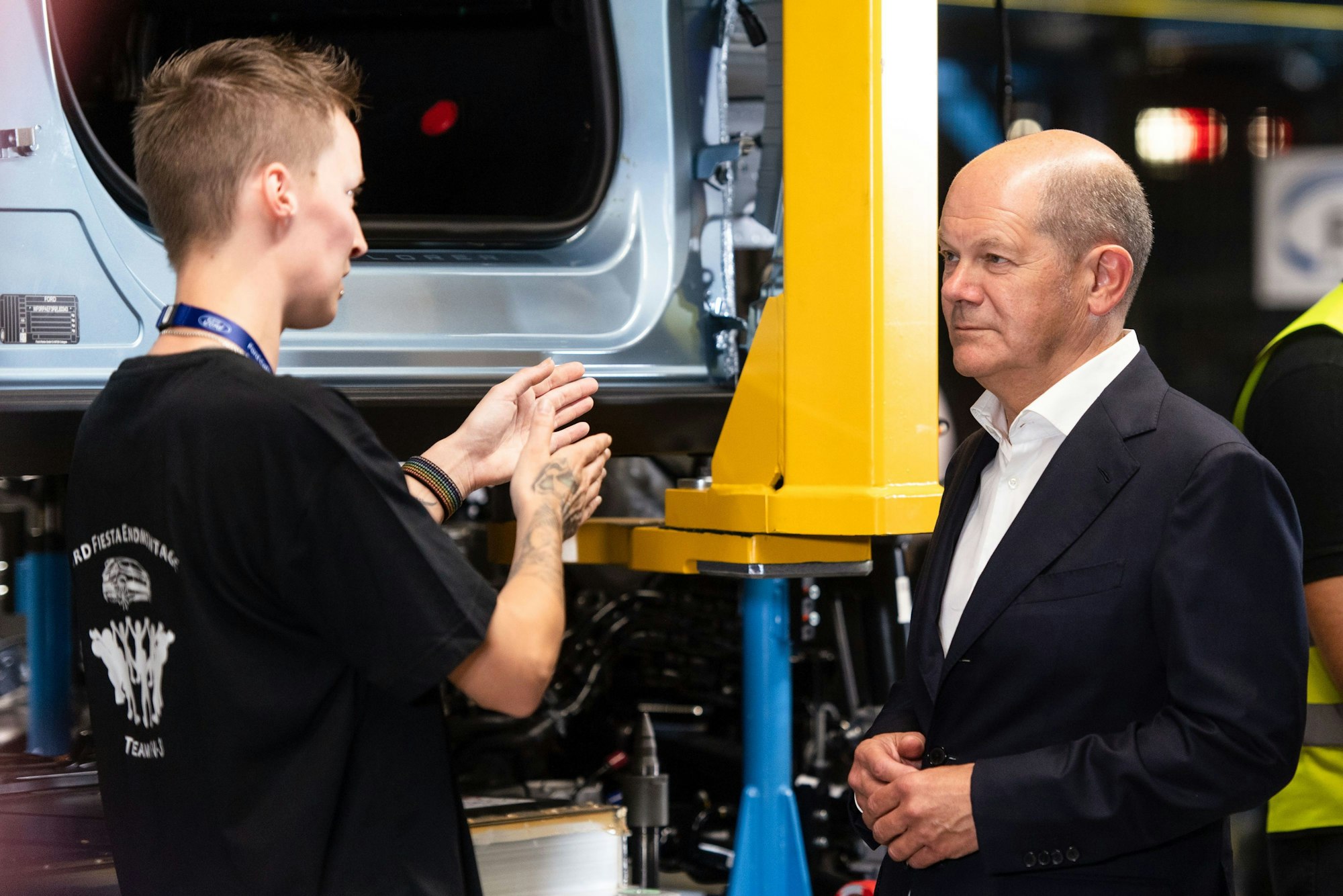 Bundeskanzler Olaf Scholz (r, SPD) spricht mit einer Mitarbeiterin.