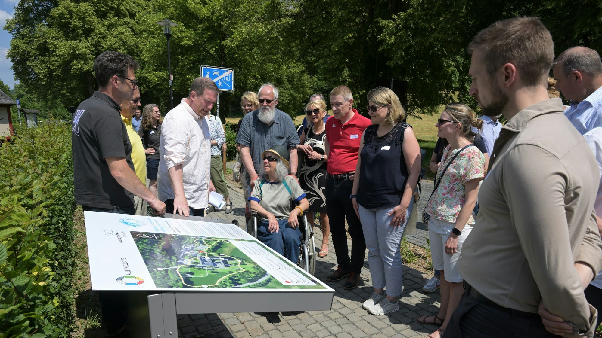 Menschen stehen um ein Info-Schild herum.