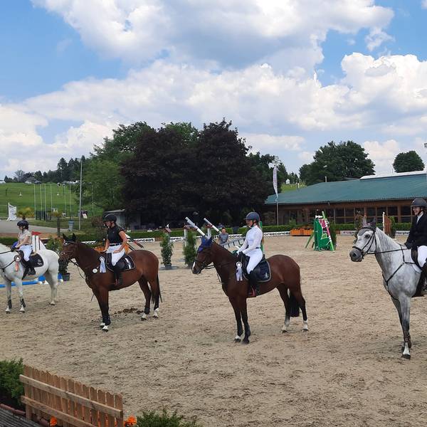 Temperaturen wie im Hochsommer auf dem Silberberghof bei Wipperfürth-Kreuzberg. Reiter und Reiterinnen sitzen auf Pferden in einer Reihe.