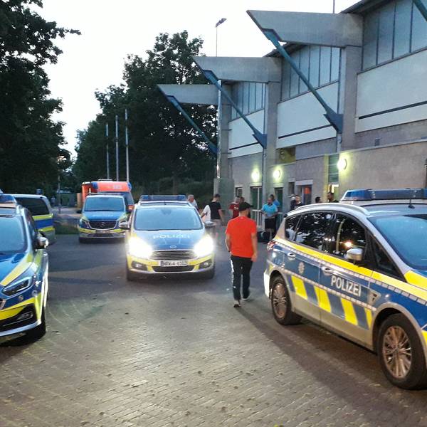 Fünf Streifenwagen stehen vor der Spielstätte bereit, nachdem es dort zu Ausschreitungen gekommen war.