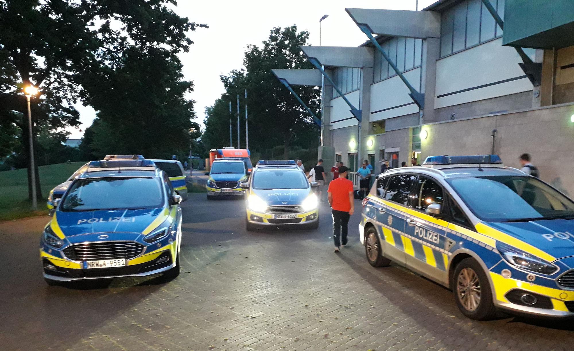 Fünf Streifenwagen stehen vor der Spielstätte bereit, nachdem es dort zu Ausschreitungen gekommen war.