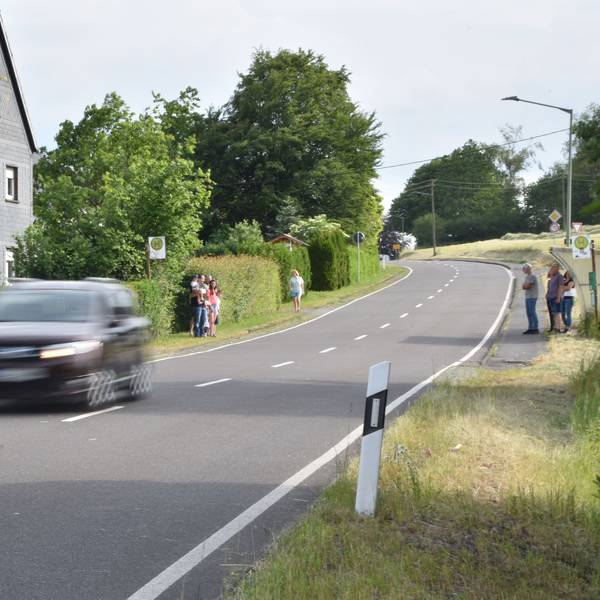 Ein Auto fährt eine Landstraße entlang.