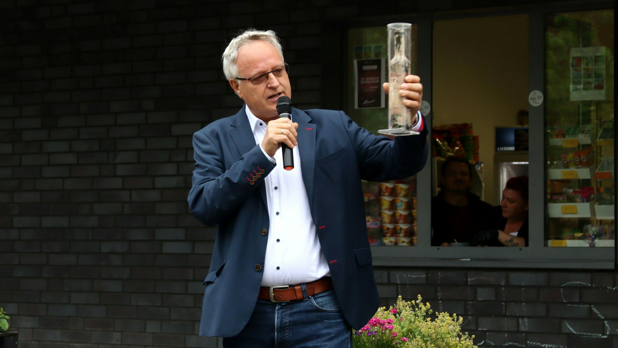 Bernhard Helfer hält eine Flasche Flutwein in den Händen.