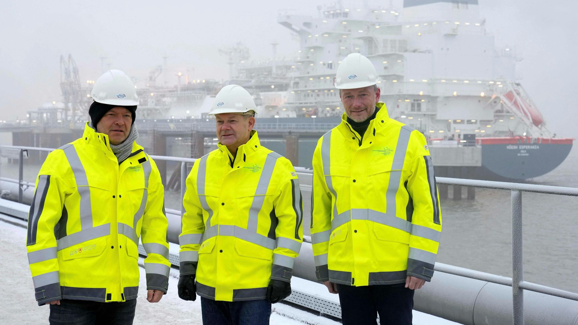 Robert Habeck, Olaf Scholz und Christian Lindner, hier bei einem winterlichen Termin zu Begrüßung eines Flüssiggas-Terminalschiffs in Wilhelmshaven 2022.afp