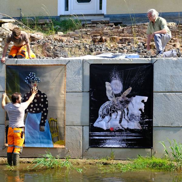 Zwei Bauhofmitarbeiter und der Kurator Jürgen A. Roder installieren die Werke der diesjährigen Ausstellung.