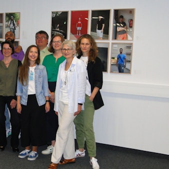 Damian Zimmermann, Bibliotheksleiterin Marion Weinberg sowie Vertreter des Käthe-Kollwitz-Museum und von Outline stehen vor einigen Porträts.